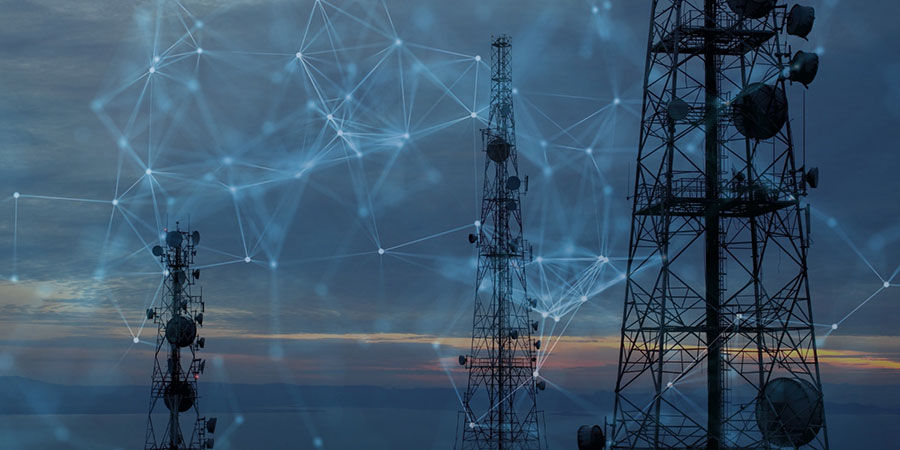 Telecom towers linked by a network mesh at dusk